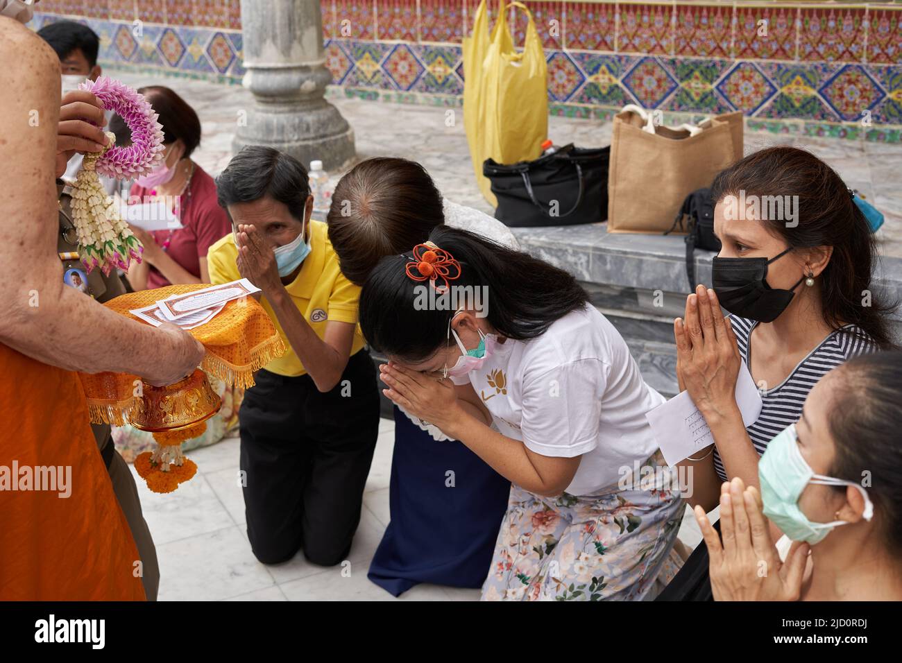 Bangkok, Thailand, 16. februar 2022: Frauen beten mit Angeboten an einen Mönch in einem Tempel Stockfoto