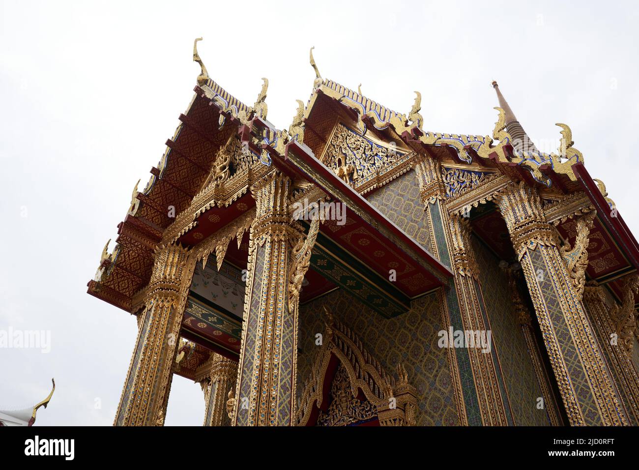 Bangkok, Thailand, 16. februar 2022: Oberer Teil des Eingangs eines buddhistischen Tempels mit goldenen Figuren geschmückt Stockfoto