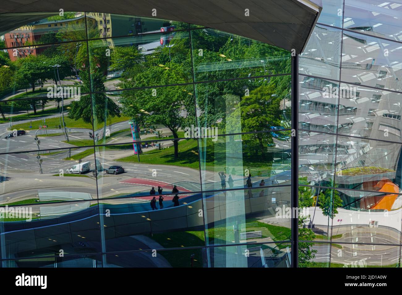 Reflexionen der Umgebung und der Trias-Brücke in der Glasfassade der BMW World München, 15.5.22 Stockfoto