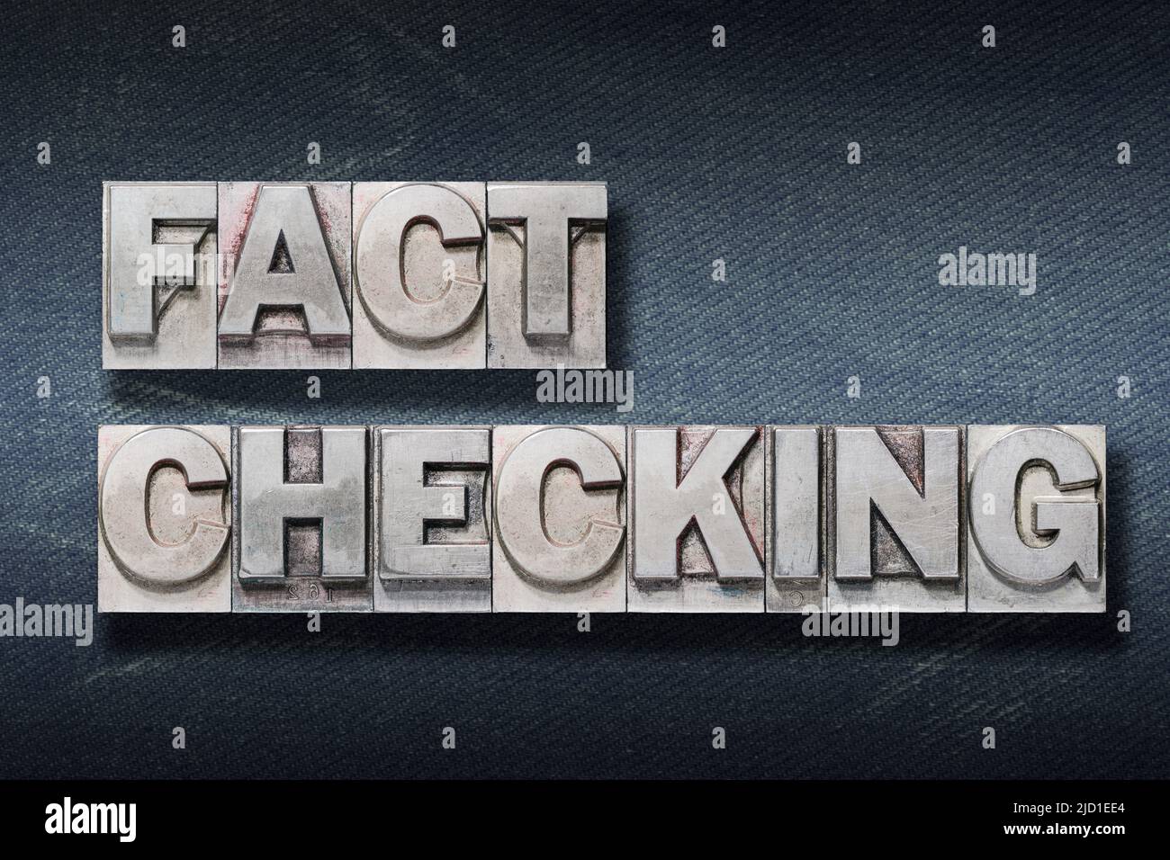 Fact Checking Phrase aus Metallic-Buchdruck auf dunklem Jeans-Hintergrund Stockfoto