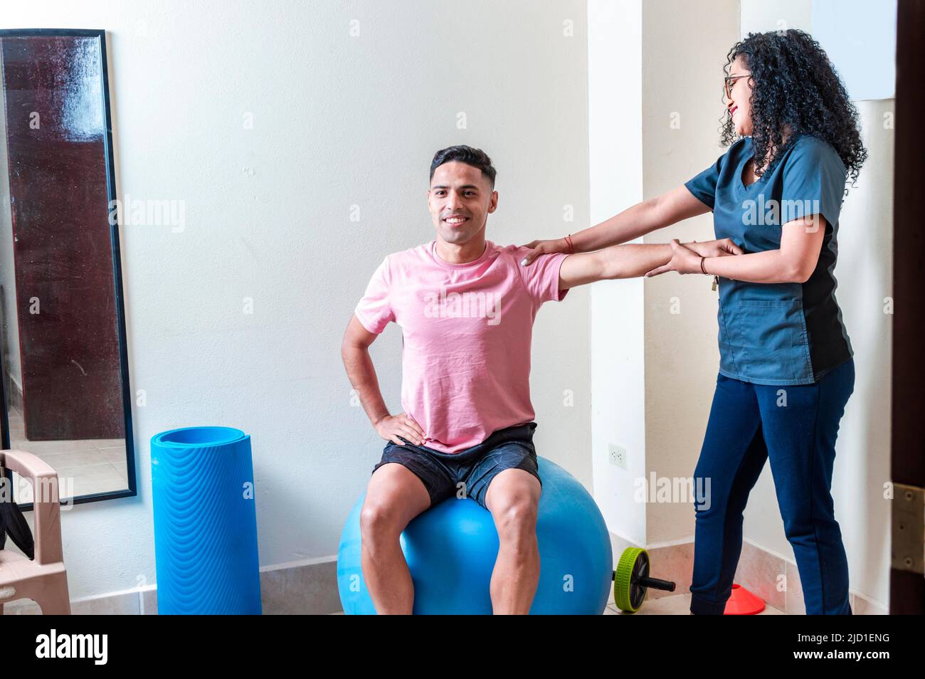 Professionelle Physiotherapeutin, die mit weiblichen Patienten im Rehabilitationszentrum arbeitet Stockfoto