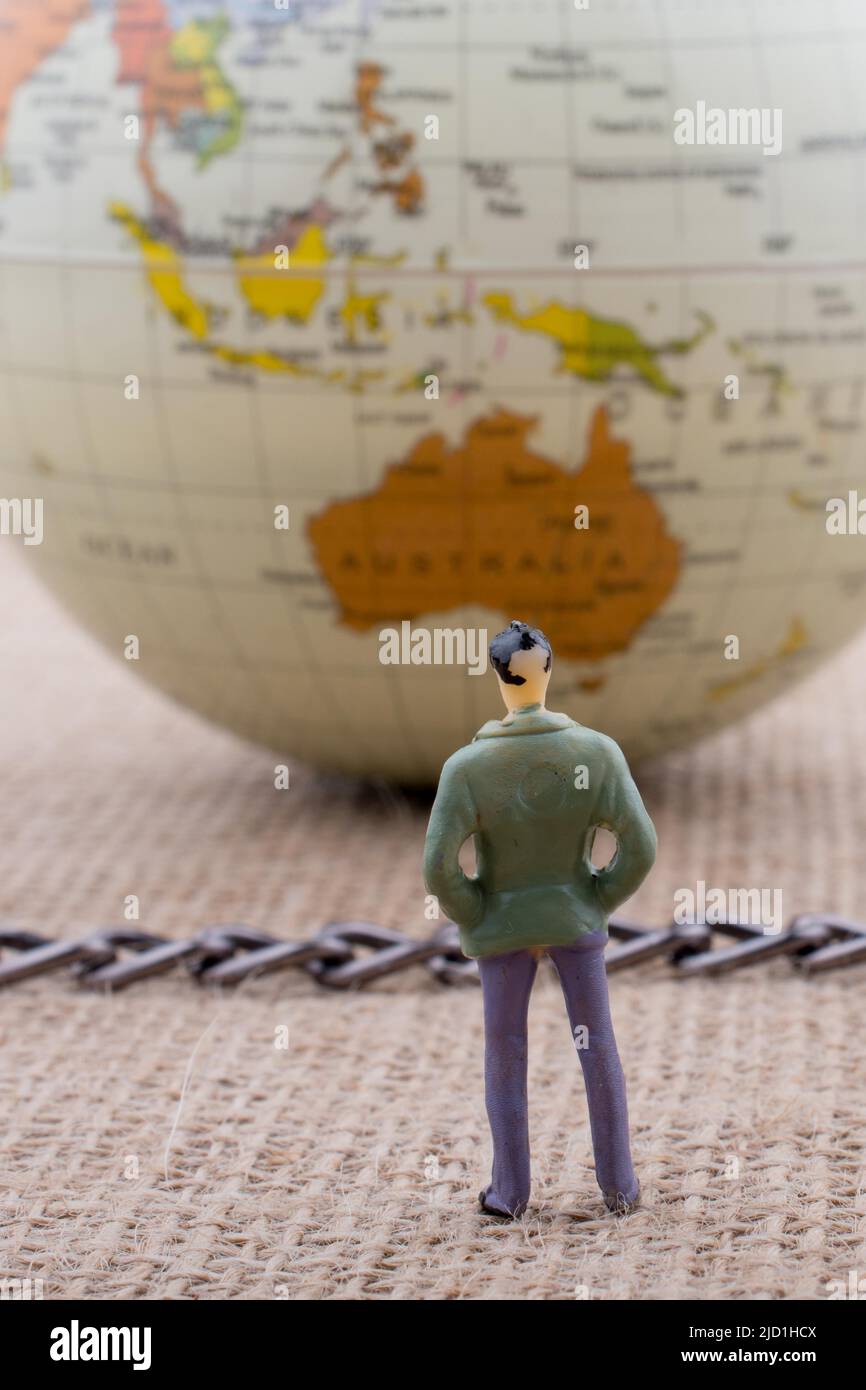 Mann-Figur und Globe mit einer Kette in der Mitte Stockfoto