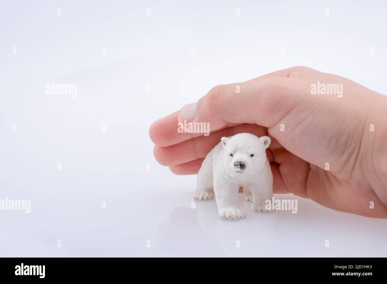 Hand hält ein Eisbär-Modell Stockfoto