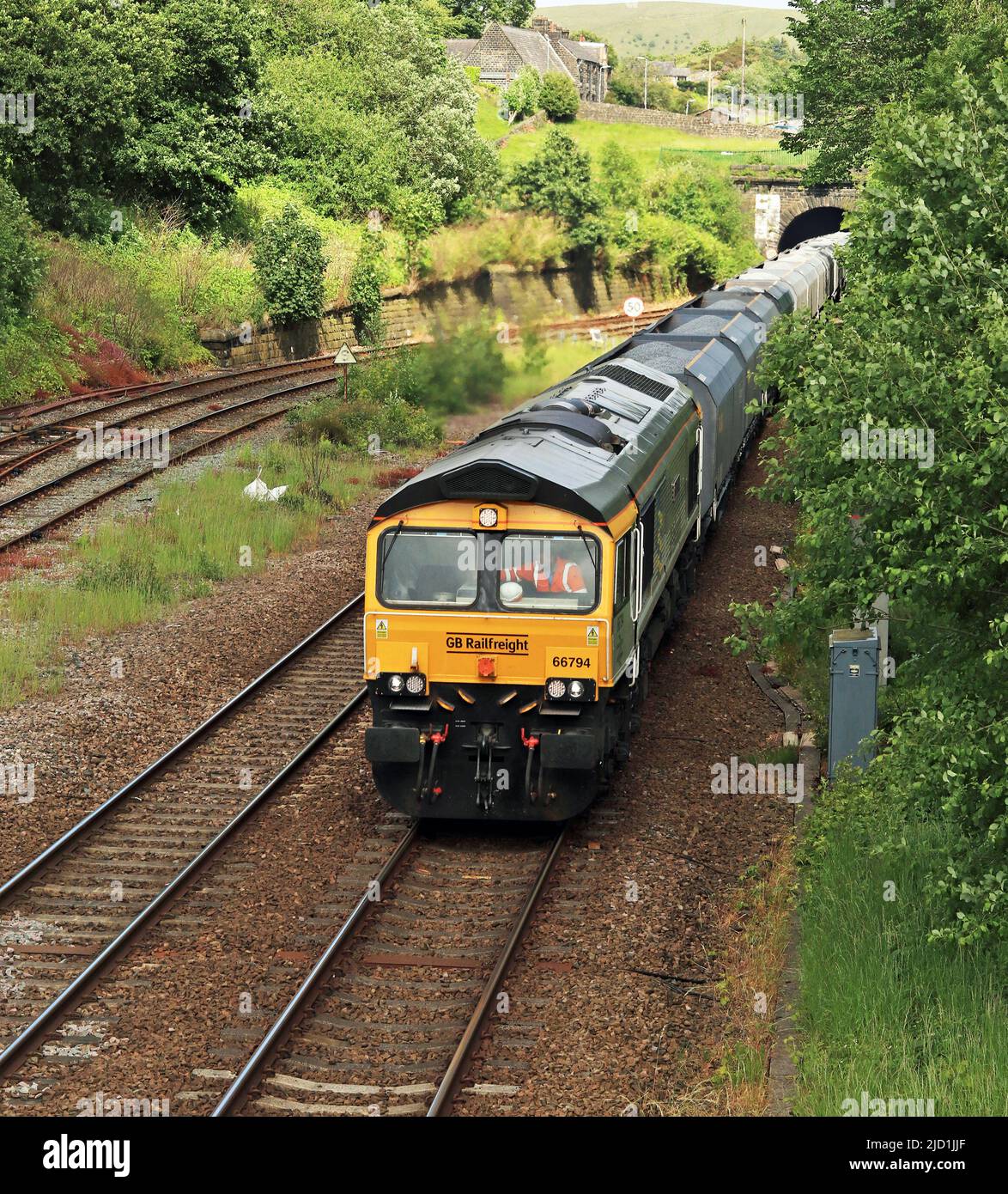 Die GBRF-Diesellokomotive 66794 fährt an der Kreuzung Hall Royd vorbei und verlässt den Millwood-Tunnel östlich von Todmorden mit seinem Zug aus Bauaggregaten. Stockfoto