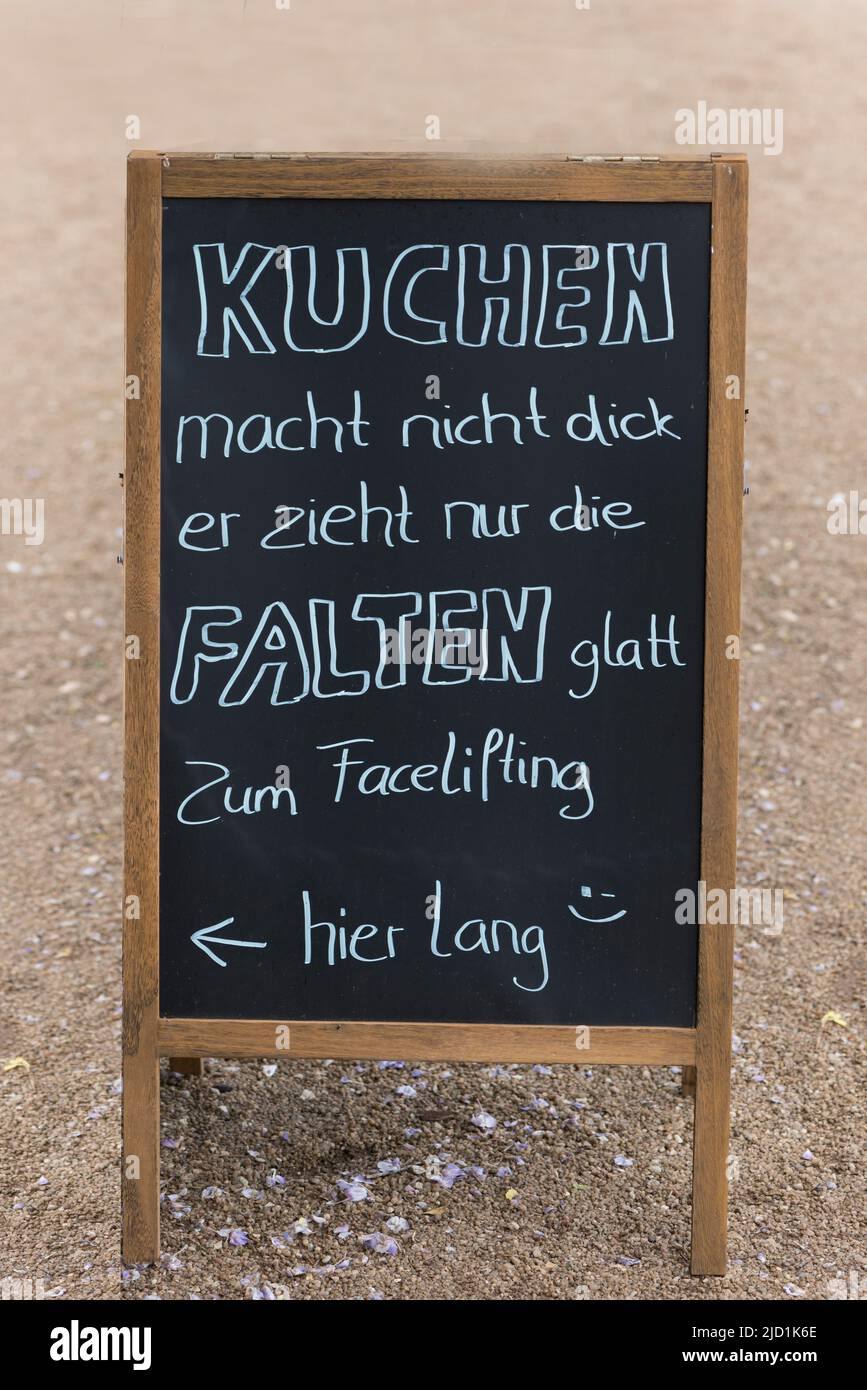 Brett mit einem Sprichwort vor einem Café, Bayern, Deutschland Stockfoto