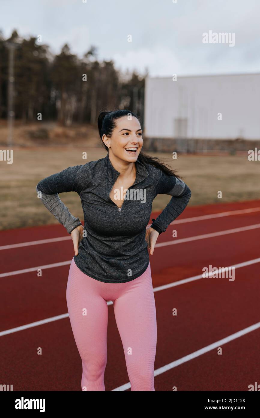 Glückliche Frau, die auf der Laufstrecke steht Stockfoto