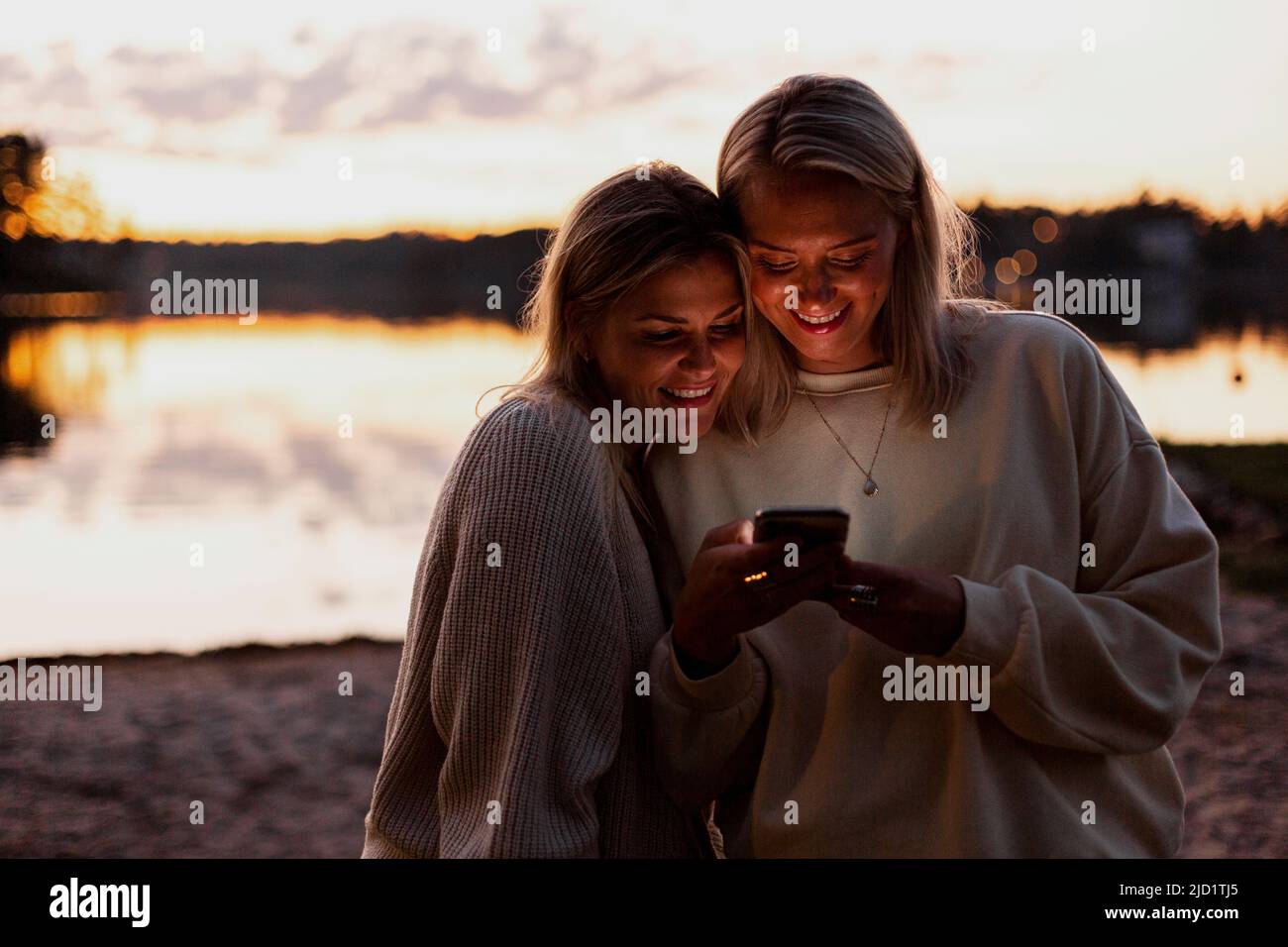 Weibliches Paar mit Handy Stockfoto