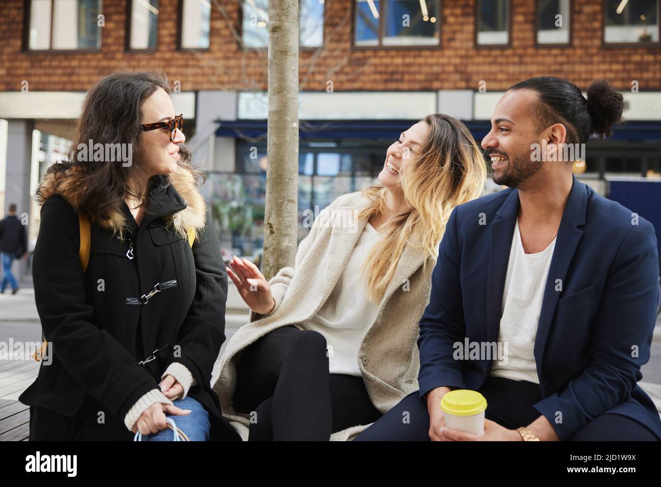 Freunde sitzen und reden im Freien Stockfoto
