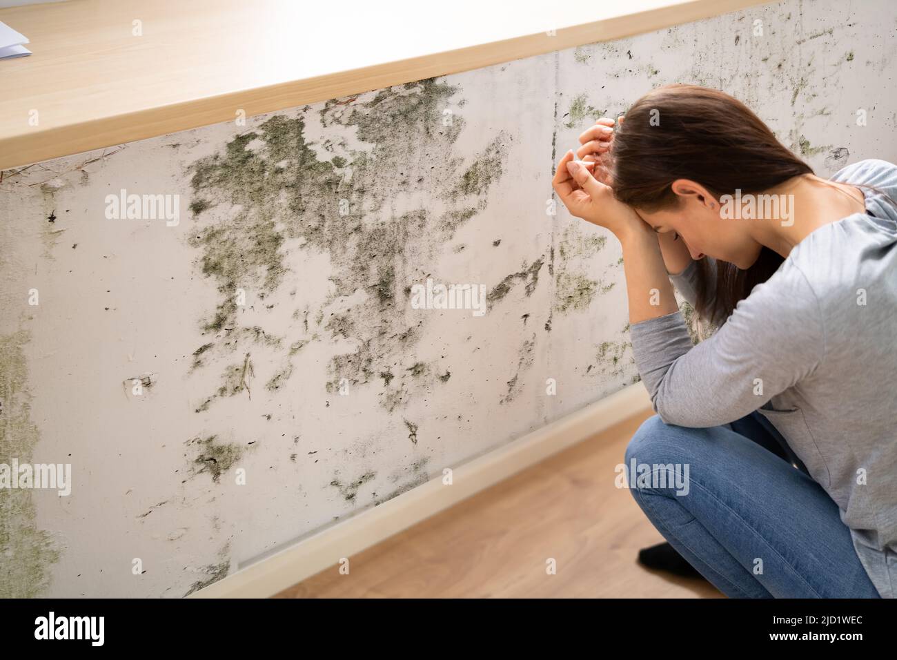 Seitenansicht einer schockierten jungen Frau, die die Form an der Wand ansieht Stockfoto