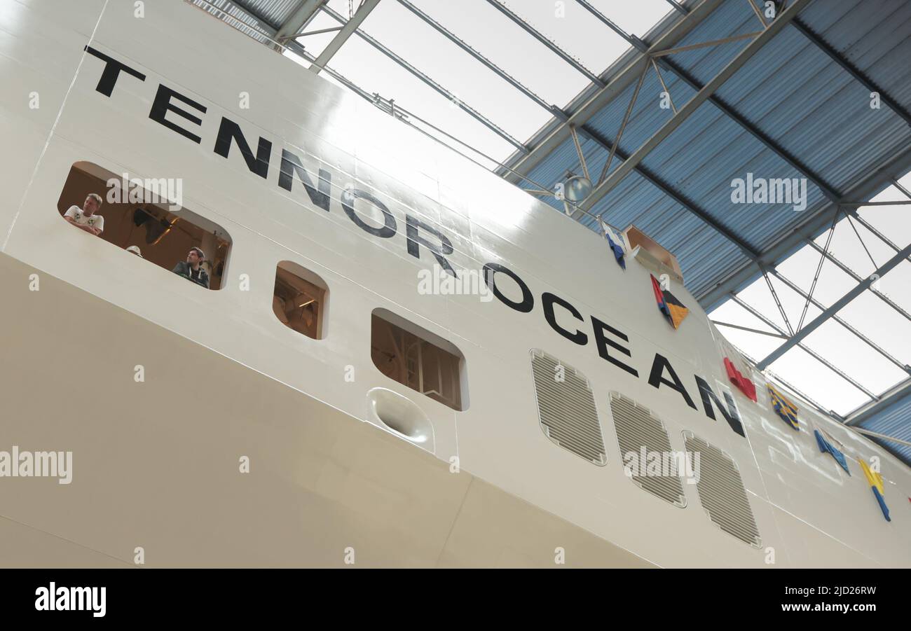 Flensburg, Deutschland. 17.. Juni 2022. Werftarbeiter der Flensburger Schiffbau-Gesellschaft beobachten die Aktion kurz vor dem Start an Bord der 'MV Tennor Ocean'. Das 210 Meter lange Schiff mit 32.770 Bruttotonnage ist für den Güterverkehr vorgesehen und bietet Platz für 279 LKW-Anhänger. Quelle: Ulrich Perrey/dpa/Alamy Live News Stockfoto