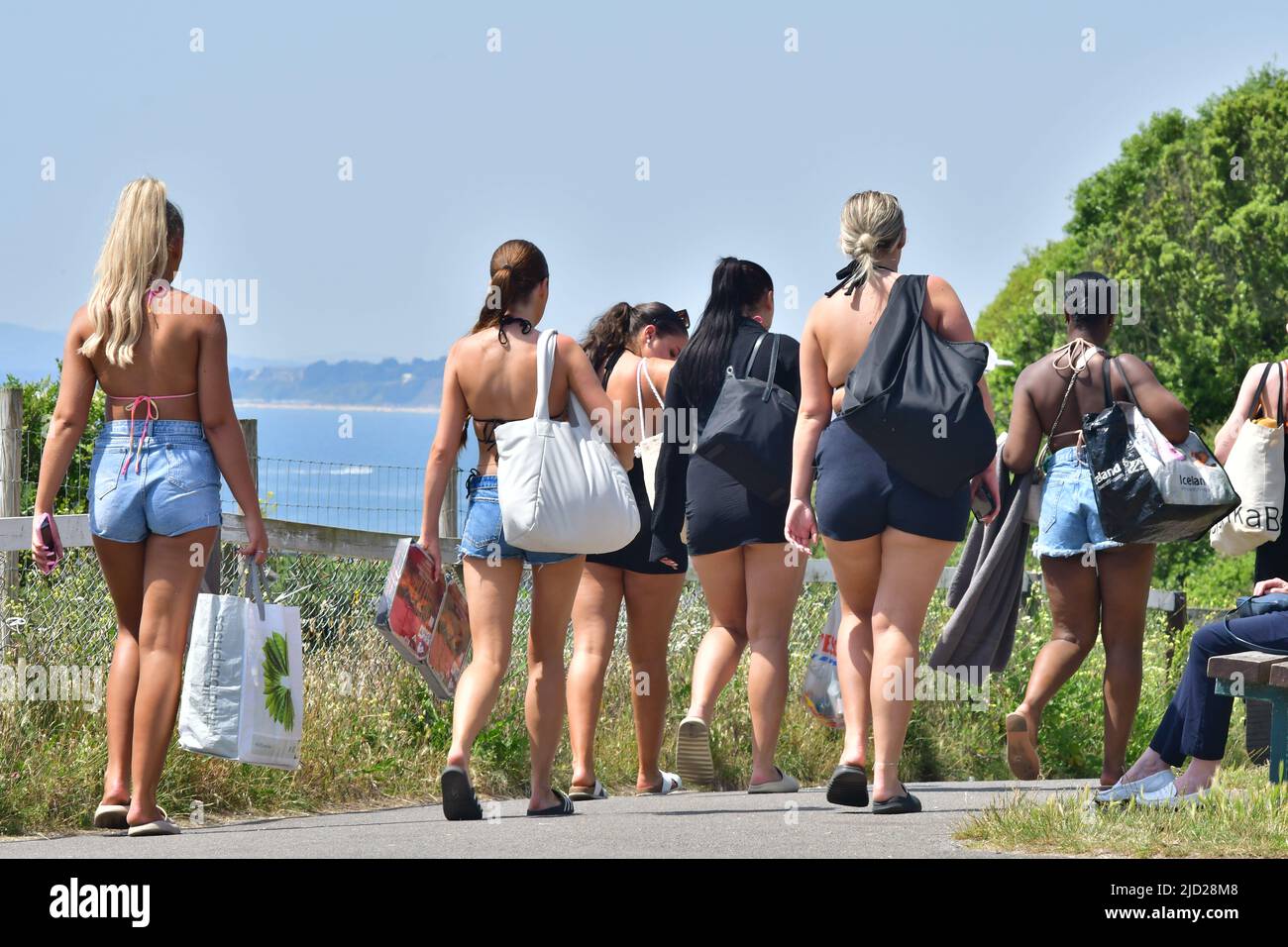 Gruppe von Mädchen, die zum Strand von Boscombe, Bournemouth, Dorset, Großbritannien, 17. Juni 2022 gehen, Heißes Wetter. Der heißeste Tag des Kurses Stockfoto