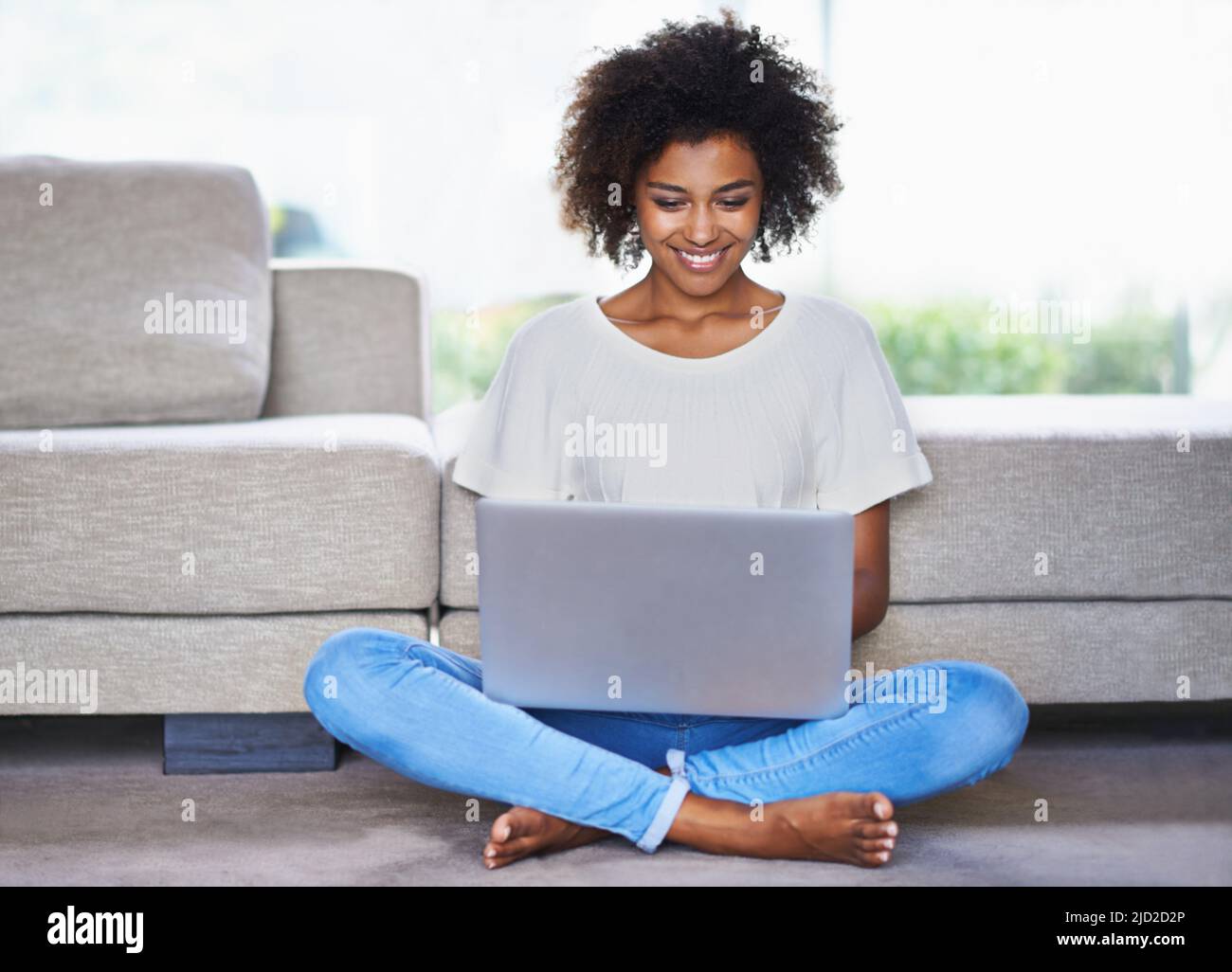 Es ist heutzutage einfach, in Verbindung zu bleiben. Aufnahme einer jungen Frau, die einen Laptop benutzt, während sie sich zu Hause entspannt. Stockfoto