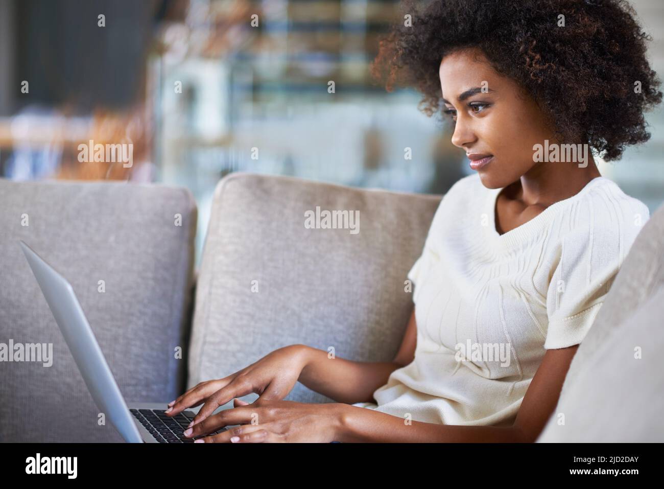 Es ist heutzutage einfach, in Verbindung zu bleiben. Aufnahme einer jungen Frau, die einen Laptop benutzt, während sie sich zu Hause entspannt. Stockfoto