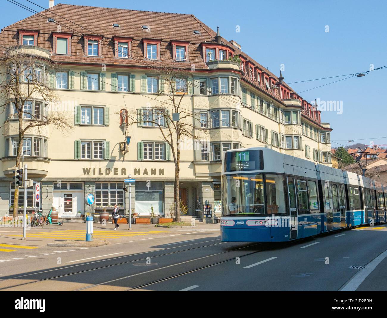 Zürich, Schweiz - März 26. 2022: Eine schnelle Straßenbahn, die historische Wohngebäude passiert Stockfoto