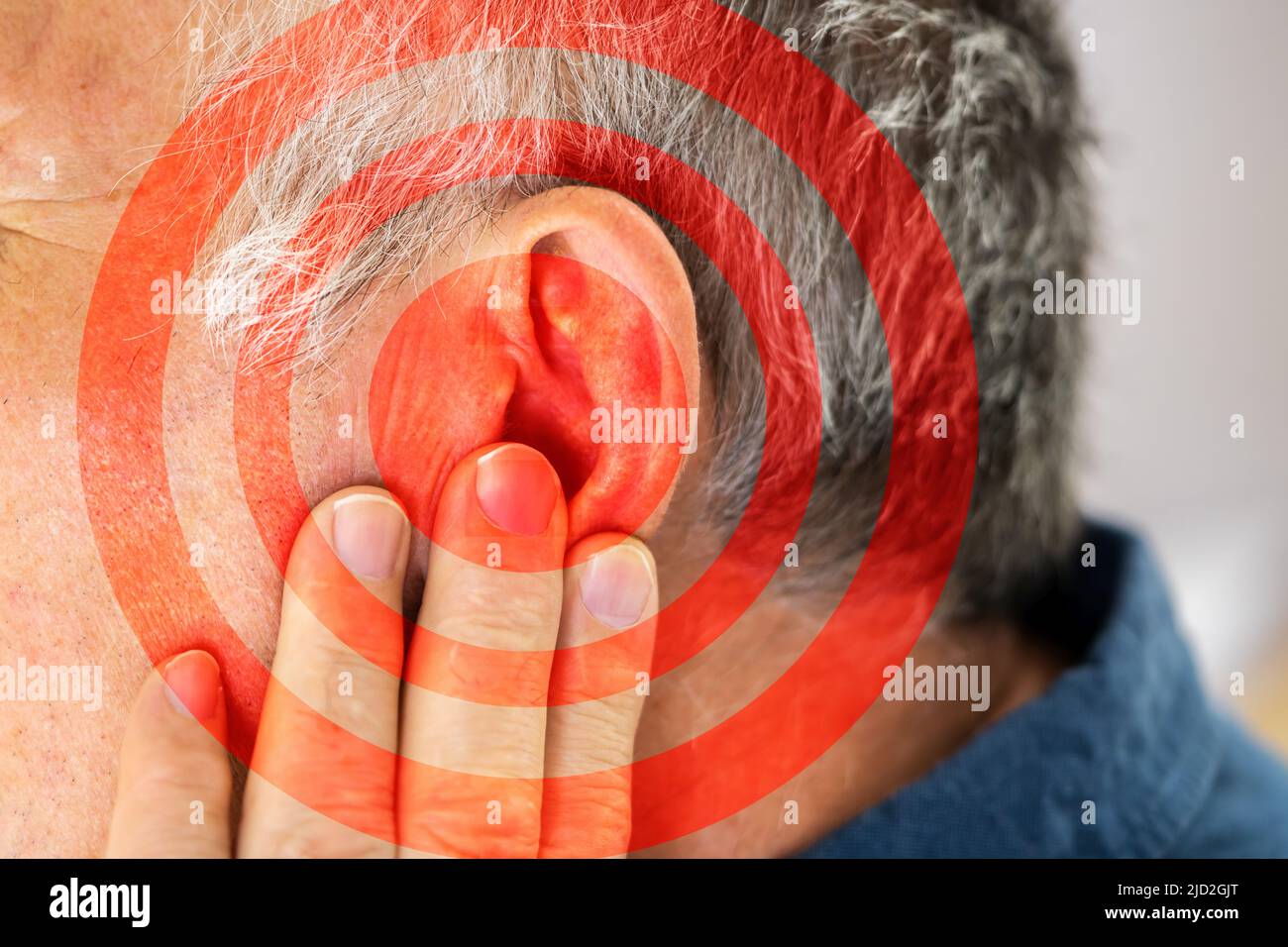 Nahaufnahme der Mann für Ohr mit Hand auf grauem Hintergrund Stockfoto