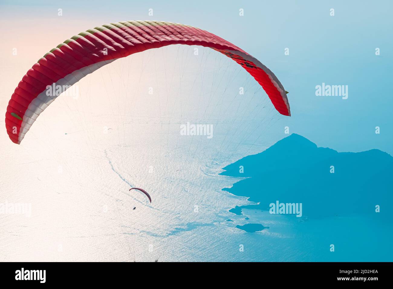 Roter offener Fallschirm am blauen Himmel. Oludeniz, Mugla. Sommer und Urlaub Hintergrund. Stockfoto