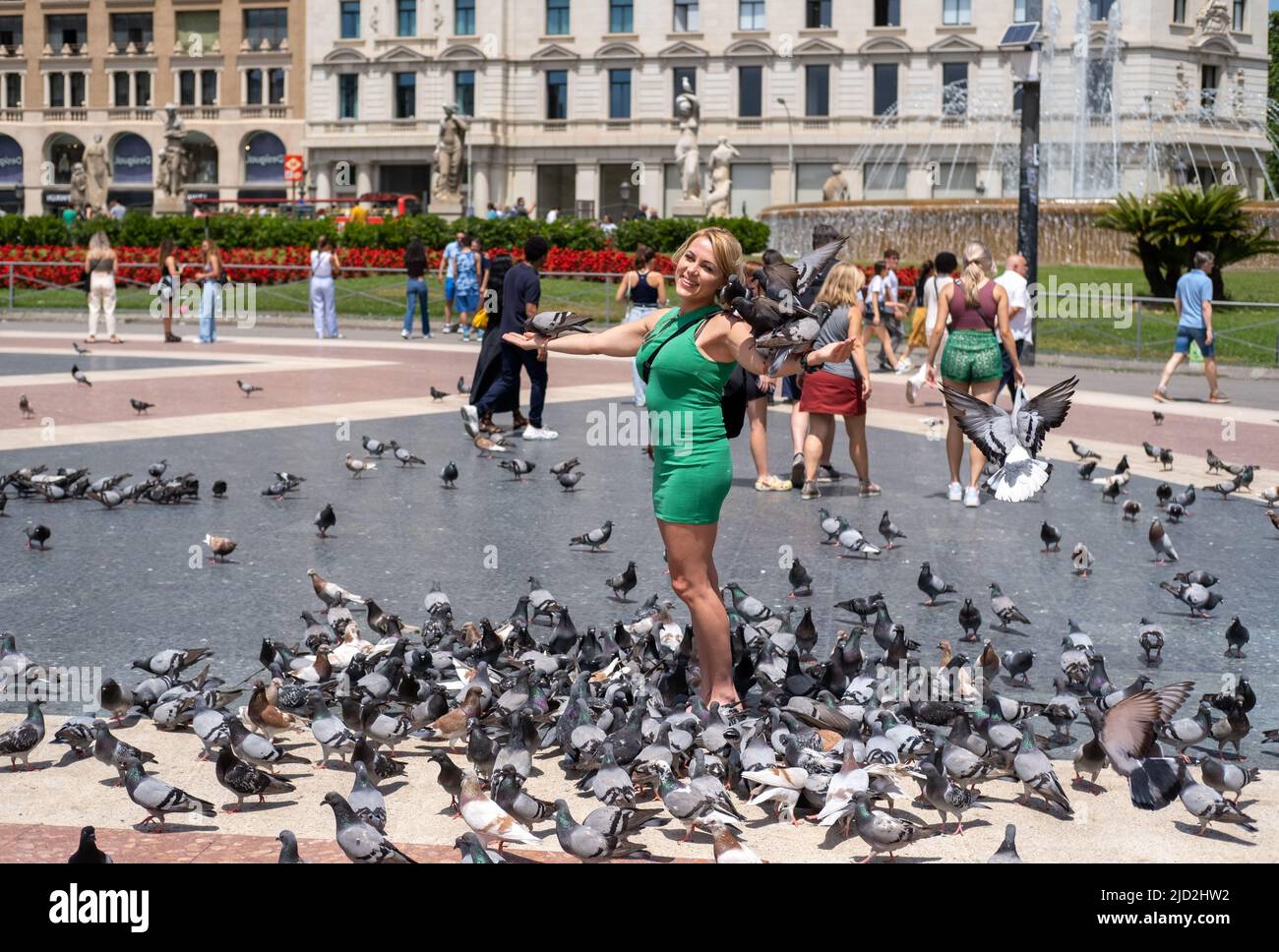 Eine Frau, die in Barcelona, Spanien, mit Tauben bedeckt ist. Stockfoto