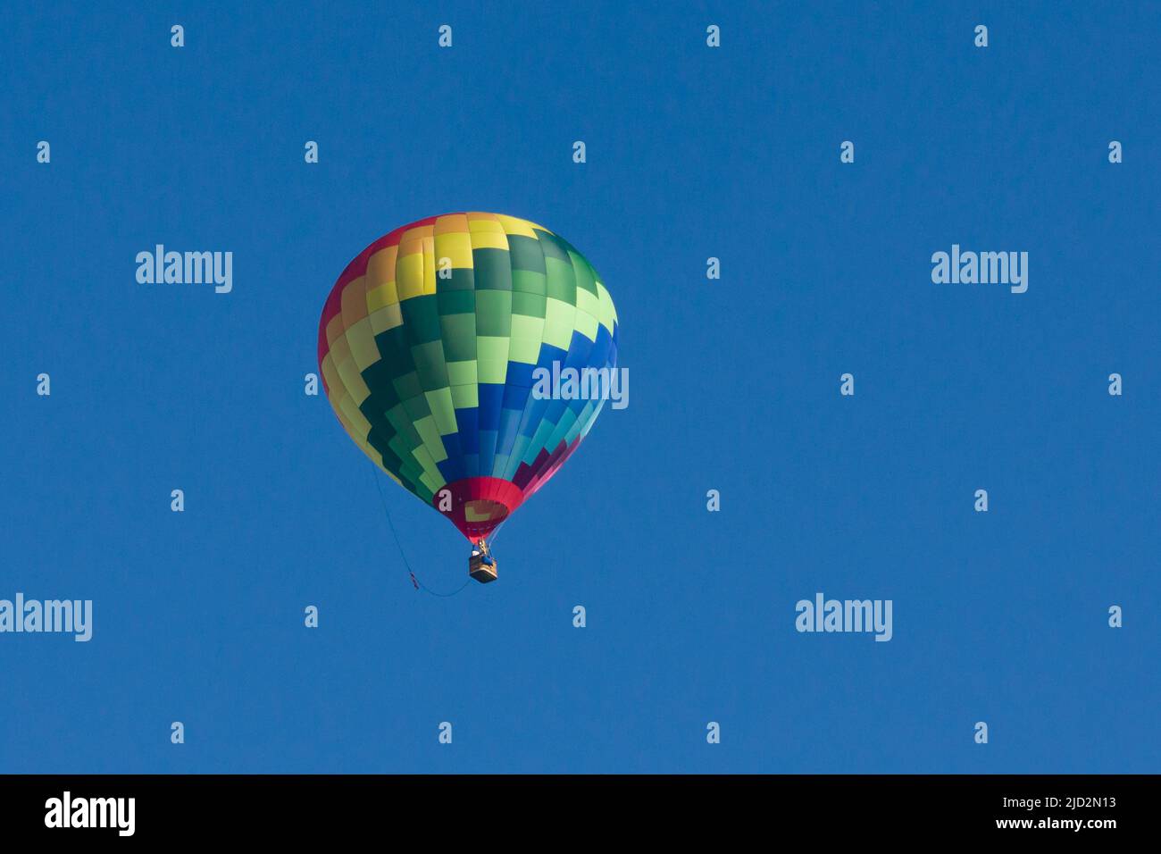 Farbenfroher Lindstrand LTL Series 1-105 Heißluftballon in einem klaren, blauen Himmel Stockfoto