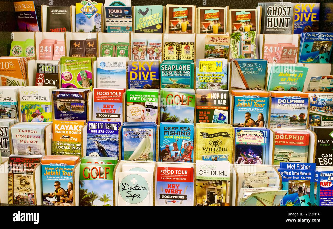 Werbebroschüren für Touristen im Gebäude des internationalen Flughafens von Key West. Stapel von vertikalen Broschüren für verschiedene Ziele oder Aktivitäten. Stockfoto
