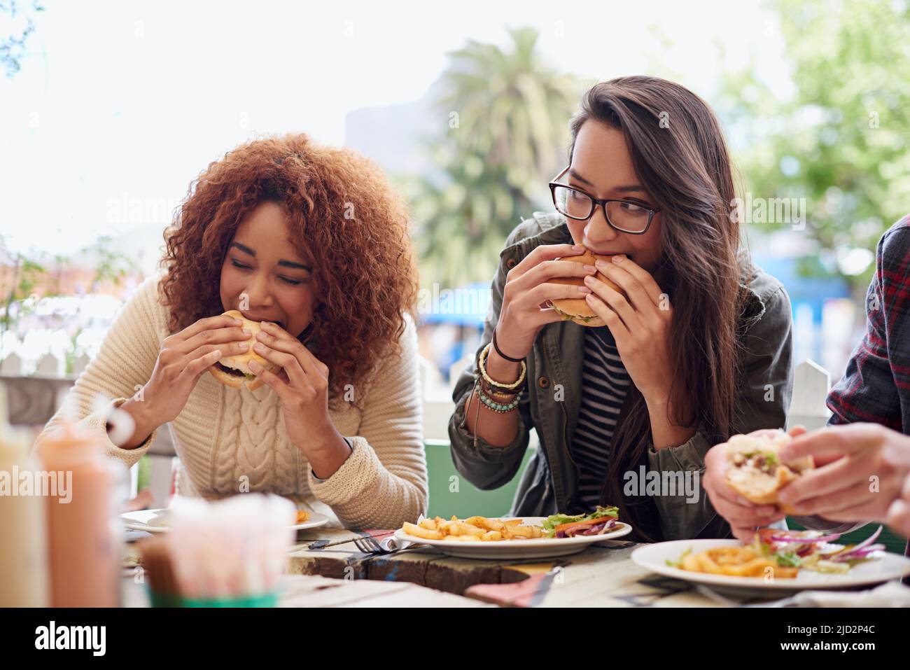 Dies ist das beste Hotel in der Stadt. Kurzer Schuss eines Freundes, der im Freien Burger isst. Stockfoto