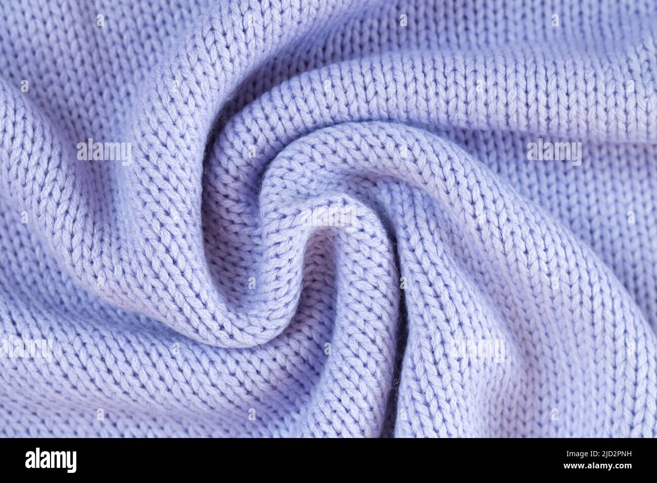 Textur aus gestricktem violettem Wolltuch. Winterpullover im Hintergrund Stockfoto