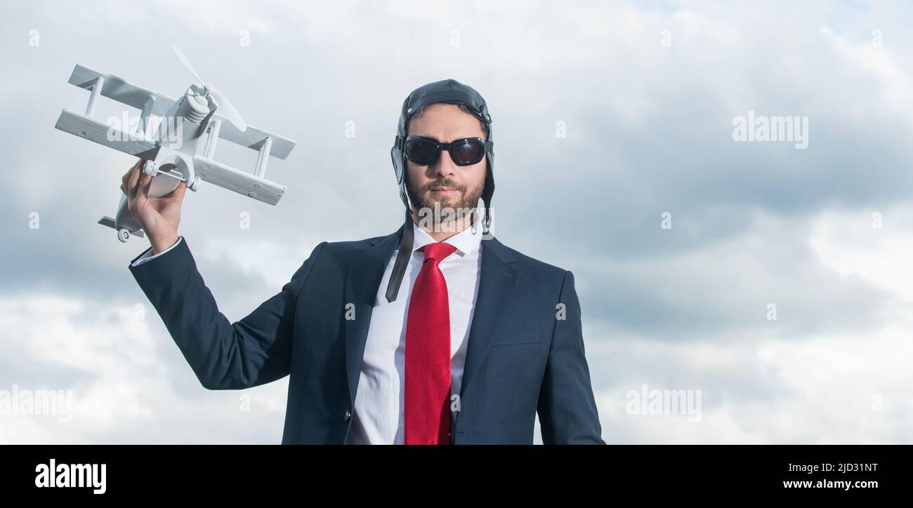 Geschäftsmann in Anzug und Pilot Hut Launch Flugzeug Spielzeug. Aspirations Stockfoto