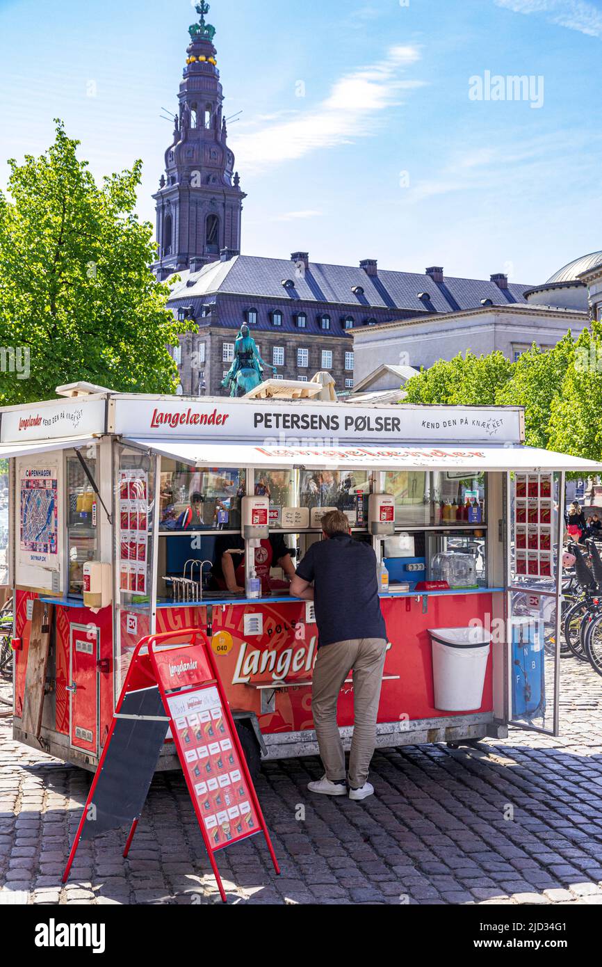 Petersens Polser Hot Dog Stand in Højbro Plads (High Bridge Square), einem öffentlichen Platz in Kopenhagen, Dänemark - überragt vom Kirchturm von Christiansborg Stockfoto