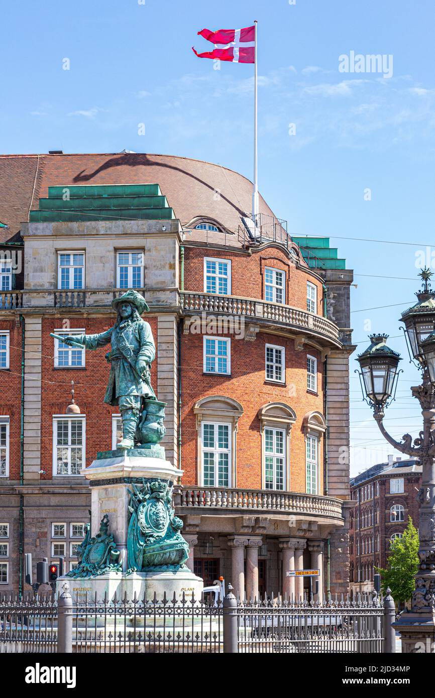 Die dänische Flagge, die über der Statue von Admiral Niels Juel am Holmen-Kanal in Kopenhagen, Dänemark, fliegt Stockfoto