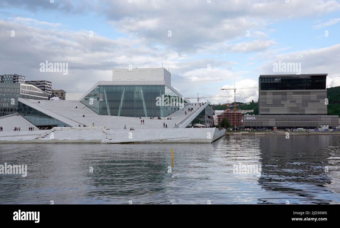 Oslo, Norwegen. 08.. Juni 2022. Das Opernhaus in der Hafenstadt Bjørvika, Austragungsort der Norwegischen Staatsoper (l). Das Dach ist zugänglich. Auf der rechten Seite das neue Gebäude des Munch Museums. Quelle: Kathrin Deckart/dpa/Alamy Live News Stockfoto