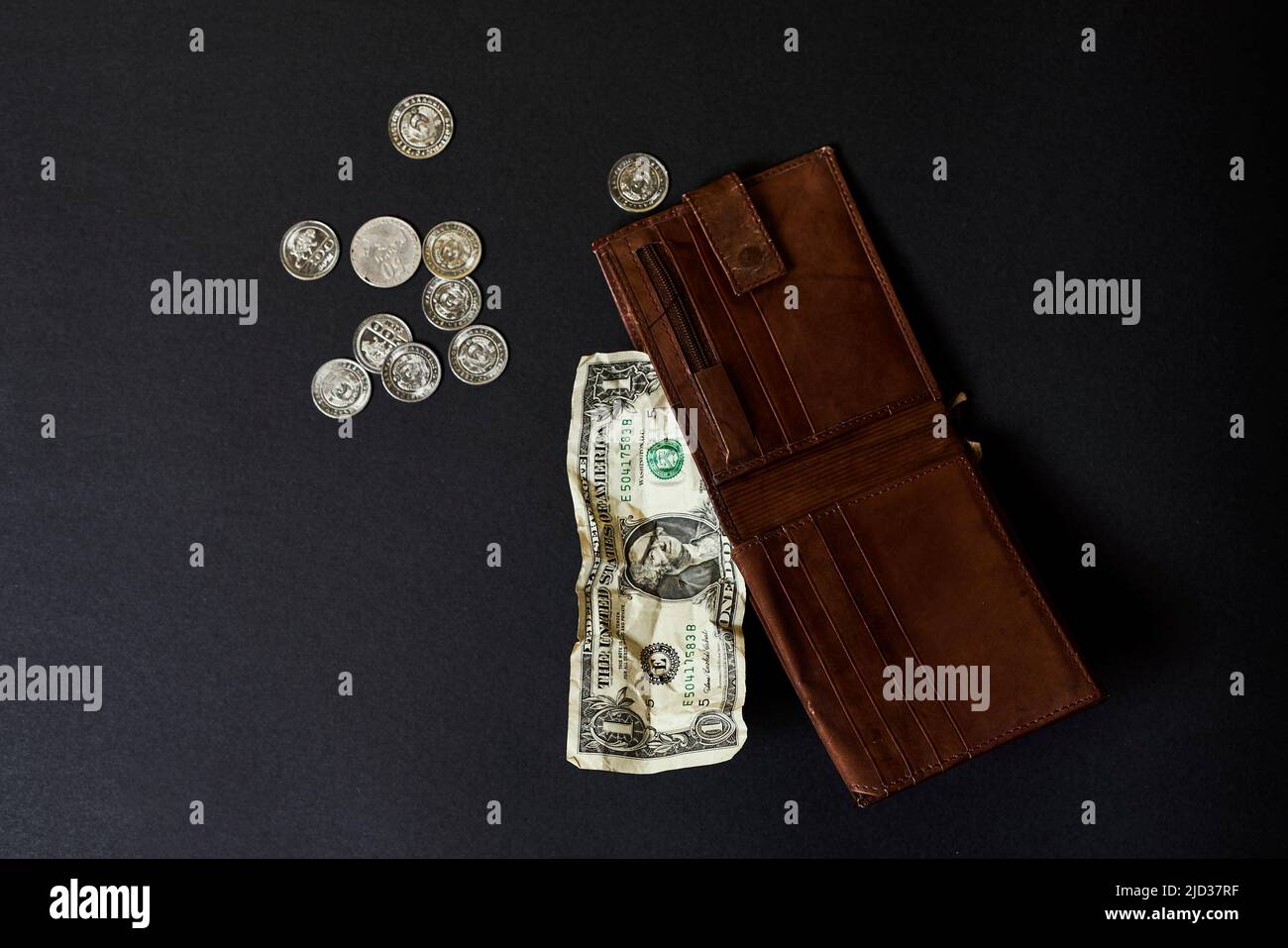 Eine einzige ein-Dollar-Rechnung in einer Ledertasche für Männer stellt Inflation, ein Währungskriegkonzept und die Situation der globalen Wirtschaftskrise dar. Geringe Schärfentiefe. Stockfoto