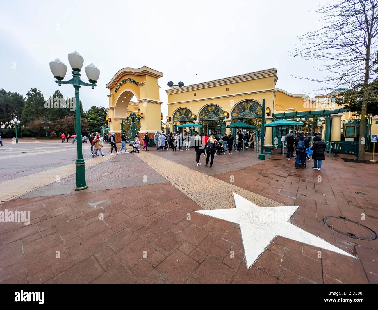Paris, France - 04/05/2022: Wasserturm und Eingangsbogen zu den Walt Disney Studios in Disneyland Paris. Wolkiges Wetter. Menschen, die zum Tor gehen. Stockfoto