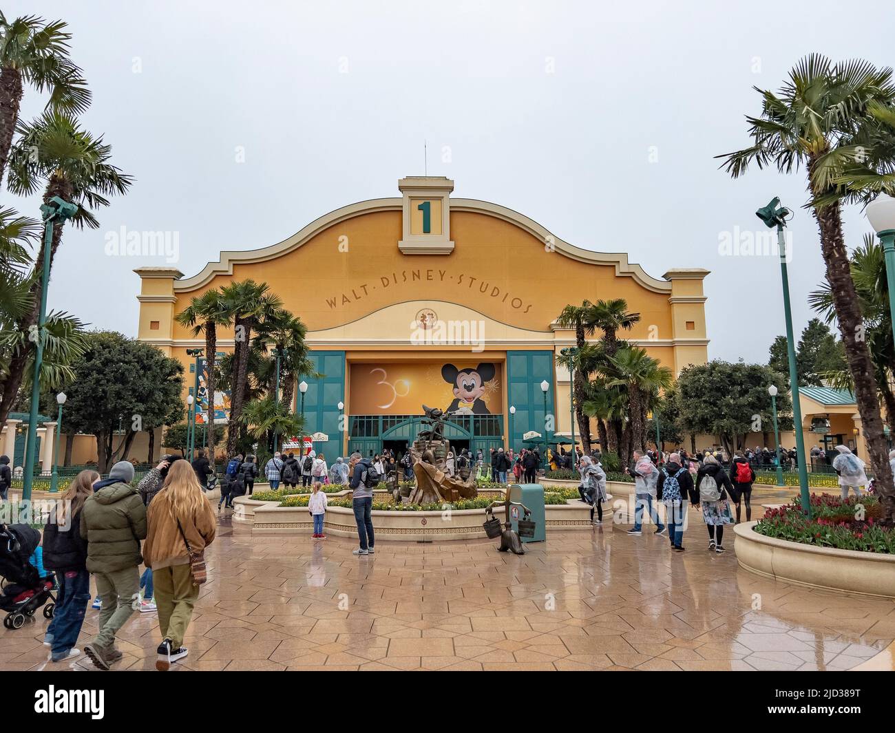 Paris, France - 04/05/2022: Wasserturm und Eingangsbogen zu den Walt Disney Studios in Disneyland Paris. Wolkiges Wetter. Menschen, die zum Tor gehen. Stockfoto