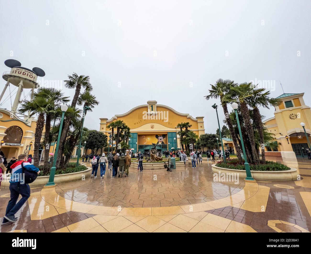Paris, France - 04/05/2022: Wasserturm und Eingangsbogen zu den Walt Disney Studios in Disneyland Paris. Wolkiges Wetter. Menschen, die zum Tor gehen. Stockfoto