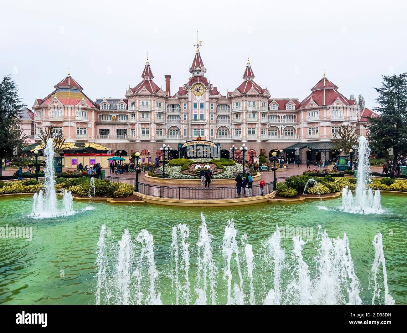 Paris, France - 04/05/2022: Vorderansicht des großen und sehr schicken Hotels in Disneyland. Pool mit Springbrunnen. Wolkiges Wetter. Stockfoto