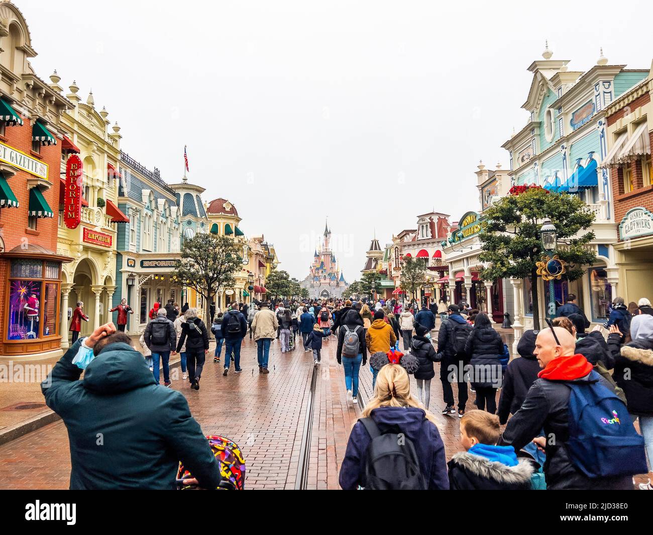 Paris, France - 04/05/2022: Dornröschenschloß bei bewölktem Wetter. Menschen, die zu Fuß zum berühmten und ikonischen Gebäude der Disneyland Parks gehen. Stockfoto