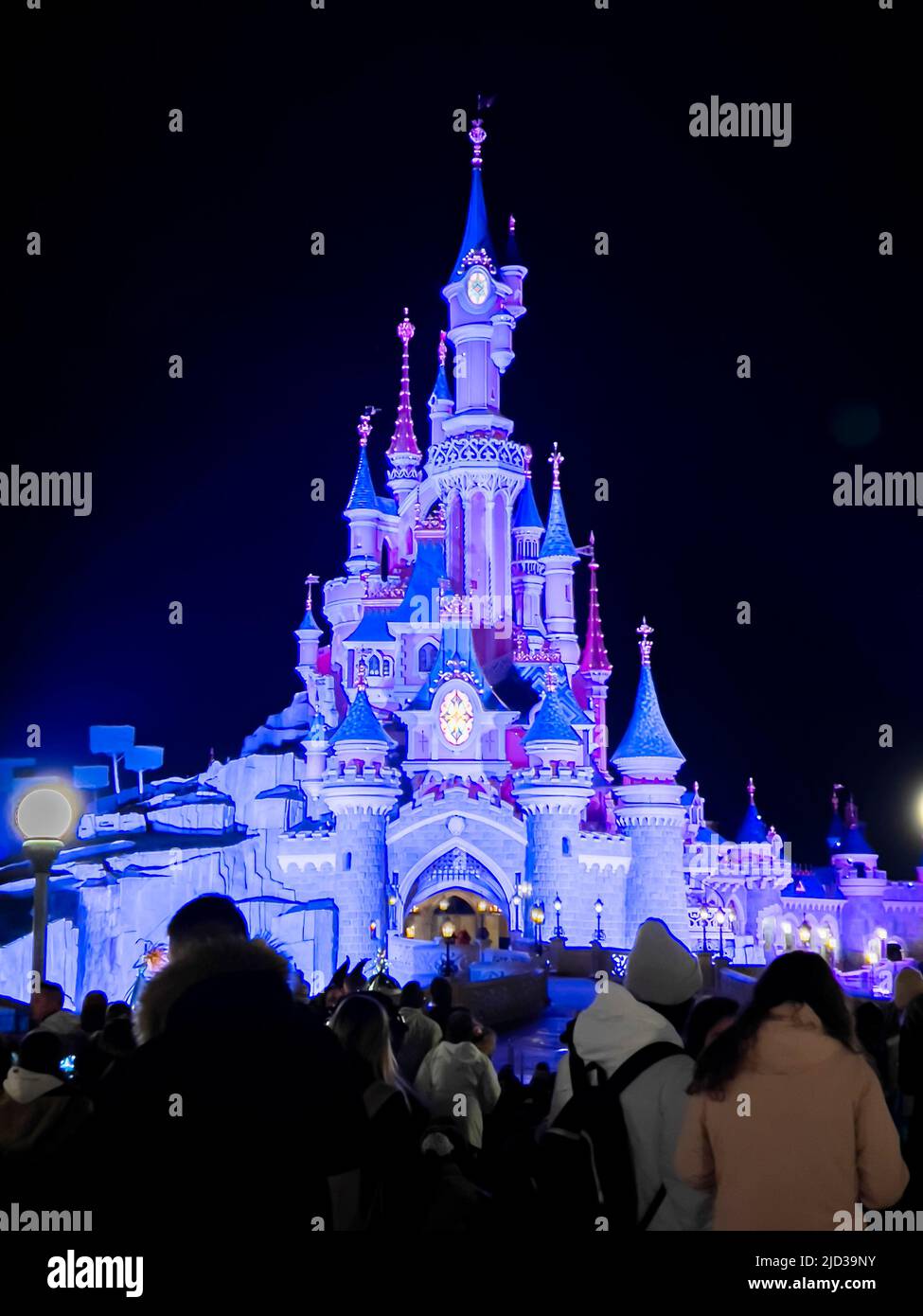 Paris, France - 04/05/2022: Farbenfroher Platz von Disneyland bei Nacht. Menschen, die herumlaufen. Stockfoto