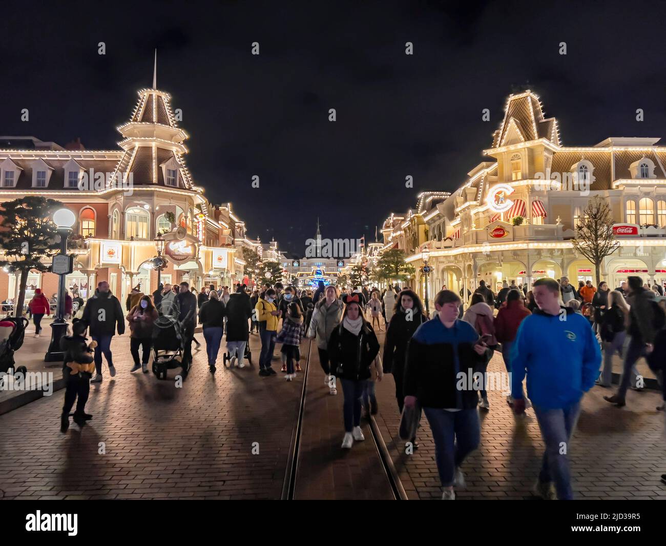Paris, France - 04/05/2022: Farbenfroher Platz von Disneyland bei Nacht. Menschen, die herumlaufen. Stockfoto