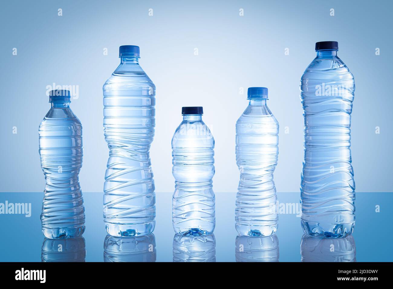 Sammlung von verschiedenen Kunststoff-Wasserflaschen isoliert auf blauem Hintergrund. Stockfoto