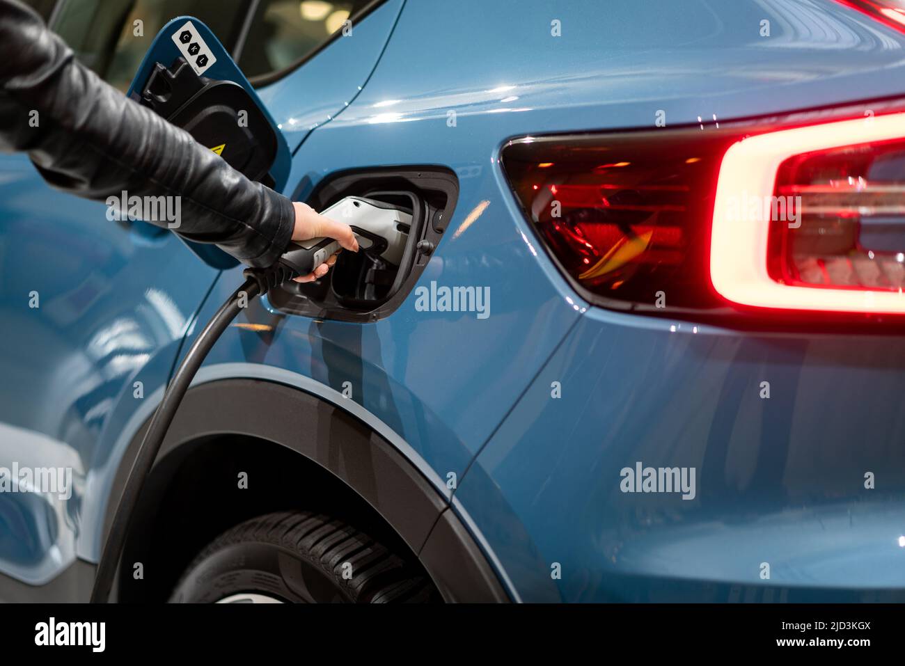 Stromversorgung zum Elektrofahrzeug anschließen, um die Batterie aufzuladen. . EV-Kraftstoffstecker im Hybridfahrzeug. Stockfoto