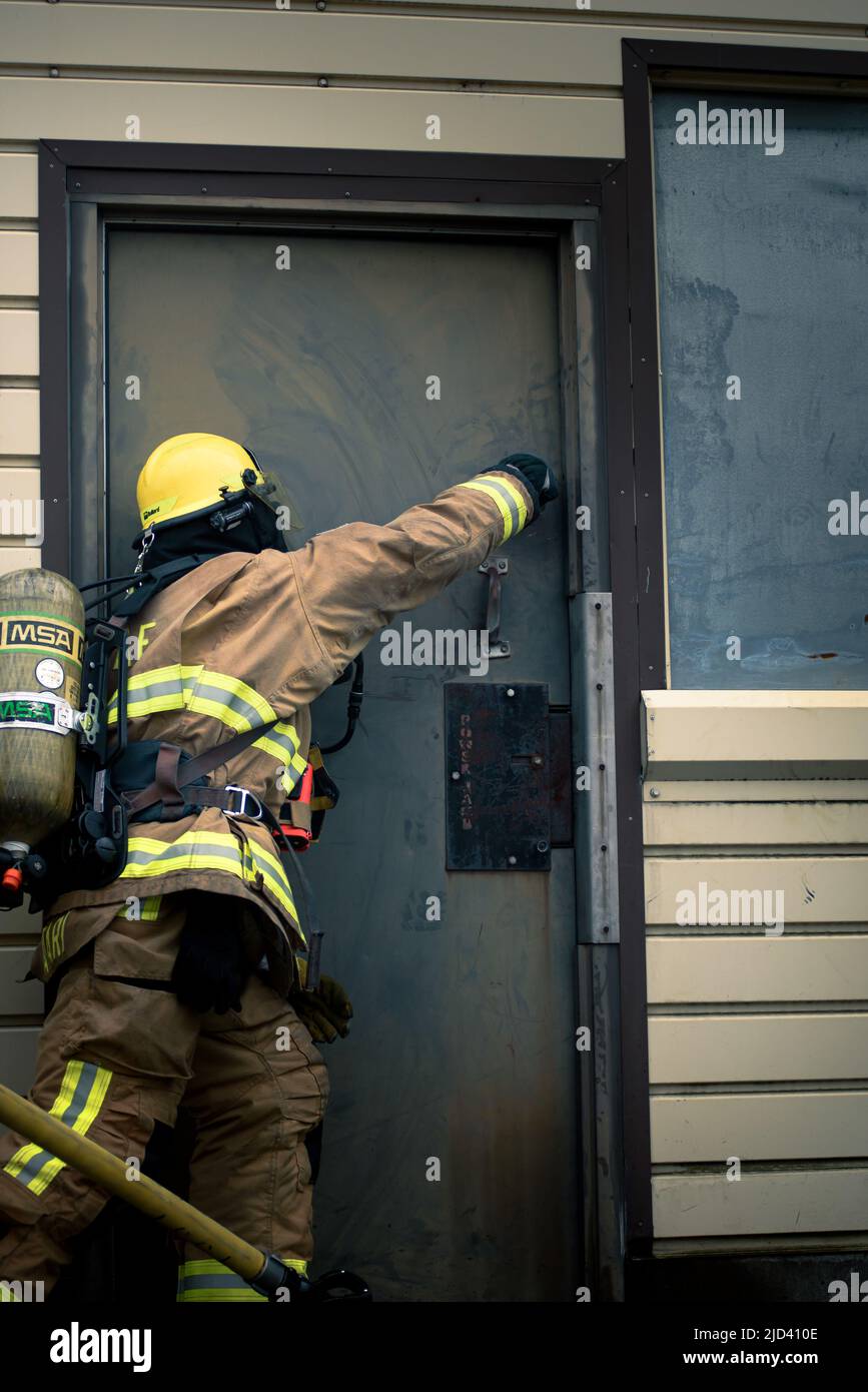 Mitglieder der 110. Wing Civil Engineering Squadron, Battle Creek Air National Guard Base, Michigan, trainieren zusammen mit lokalen japanischen Feuerwehrleuten während des Einsatzkampfes der CE Squadron (DFT) mit einem simulierten Gebäudebrand auf der Yakota Air Base, Japan, 14. Juni 2022. Das DFT-Programm bietet wertvolle Schulungsmöglichkeiten, die normalerweise nicht in Heimstationen-Szenarien verfügbar sind, und ermöglicht es Airmen, an Geräten zu trainieren, die sie wahrscheinlich während eines Einsatzes betreiben, aber möglicherweise nicht an ihrem Heimatstandort haben. (USA Foto der Air National Guard von Senior Airman Ryan Bishop) Stockfoto