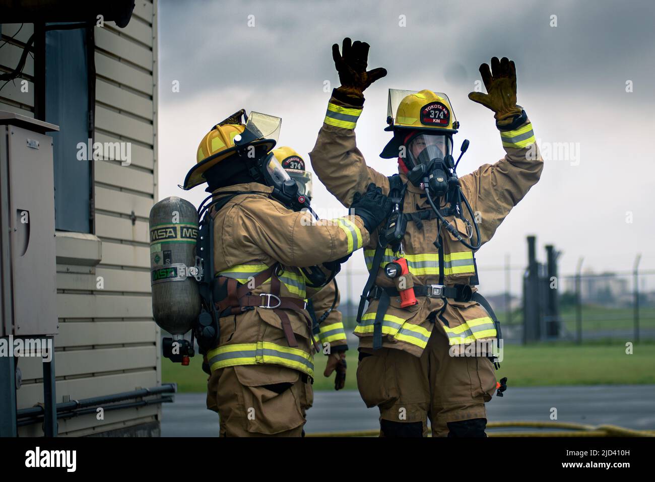 Mitglieder der 110. Civil Engineering Squadron, Battle Creek Air National Guard Base, Michigan, trainieren zusammen mit lokalen japanischen Feuerwehrleuten während des 110 CES's Deployment for Training (DFT) mit einem simulierten Gebäudebrand auf der Yakota Air Base, Japan, 14. Juni 2022. Das DFT-Programm bietet wertvolle Schulungsmöglichkeiten, die normalerweise nicht in Heimstationen-Szenarien verfügbar sind, und ermöglicht es Airmen, an Geräten zu trainieren, die sie wahrscheinlich während eines Einsatzes betreiben, aber möglicherweise nicht an ihrem Heimatstandort haben. (USA Foto der Air National Guard von Senior Airman Ryan Bishop) Stockfoto