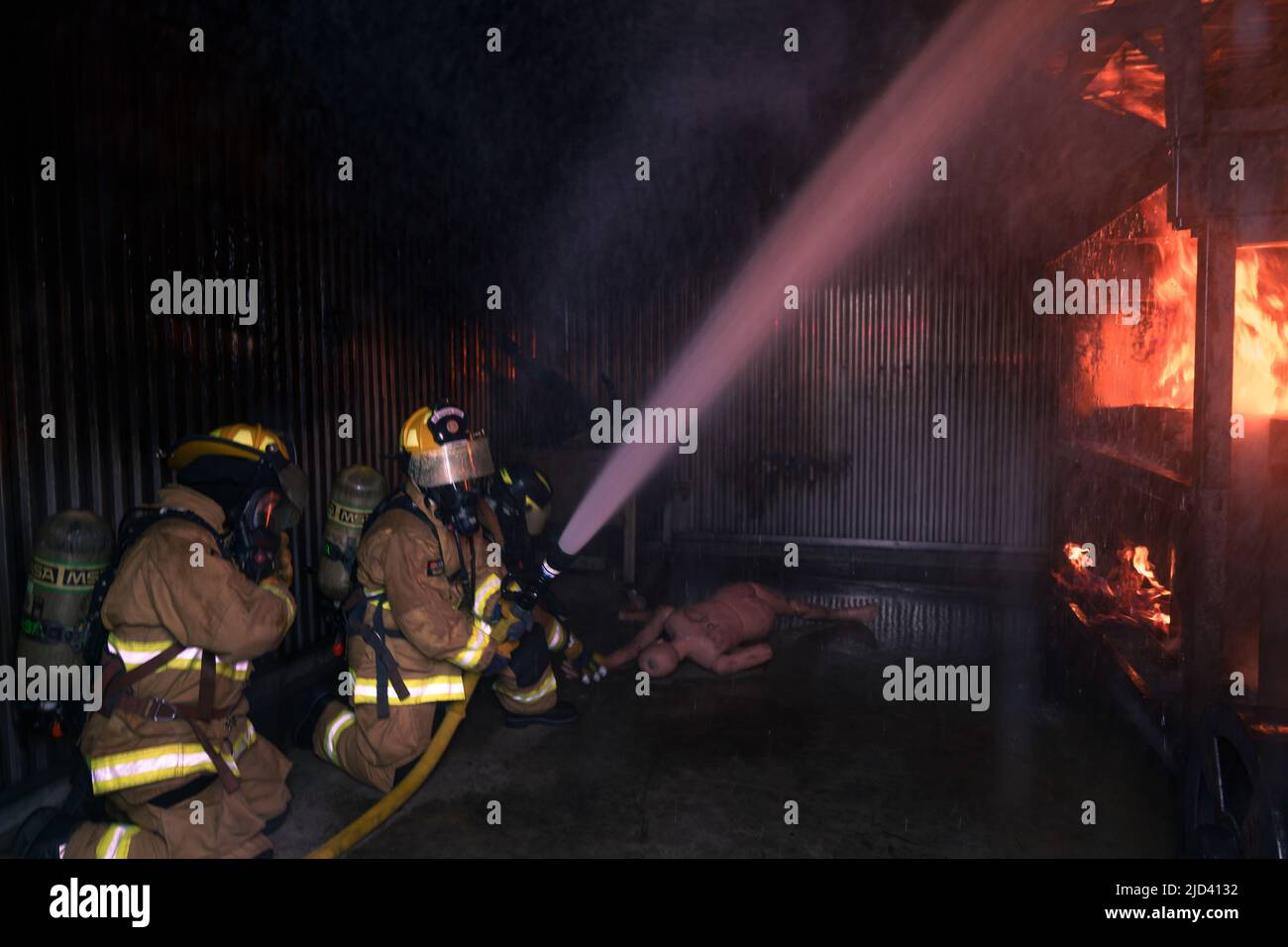 Mitglieder der 110. Wing Civil Engineering Squadron, Battle Creek Air National Guard Base, Michigan, trainieren zusammen mit lokalen japanischen Feuerwehrleuten während des Einsatzkampfes der CE Squadron (DFT) mit einem simulierten Gebäudebrand auf der Yakota Air Base, Japan, 14. Juni 2022. Das DFT-Programm bietet wertvolle Schulungsmöglichkeiten, die normalerweise nicht in Heimstationen-Szenarien verfügbar sind, und ermöglicht es Airmen, an Geräten zu trainieren, die sie wahrscheinlich während eines Einsatzes betreiben, aber möglicherweise nicht an ihrem Heimatstandort haben. (USA Foto der Air National Guard von Senior Airman Ryan Bishop) Stockfoto