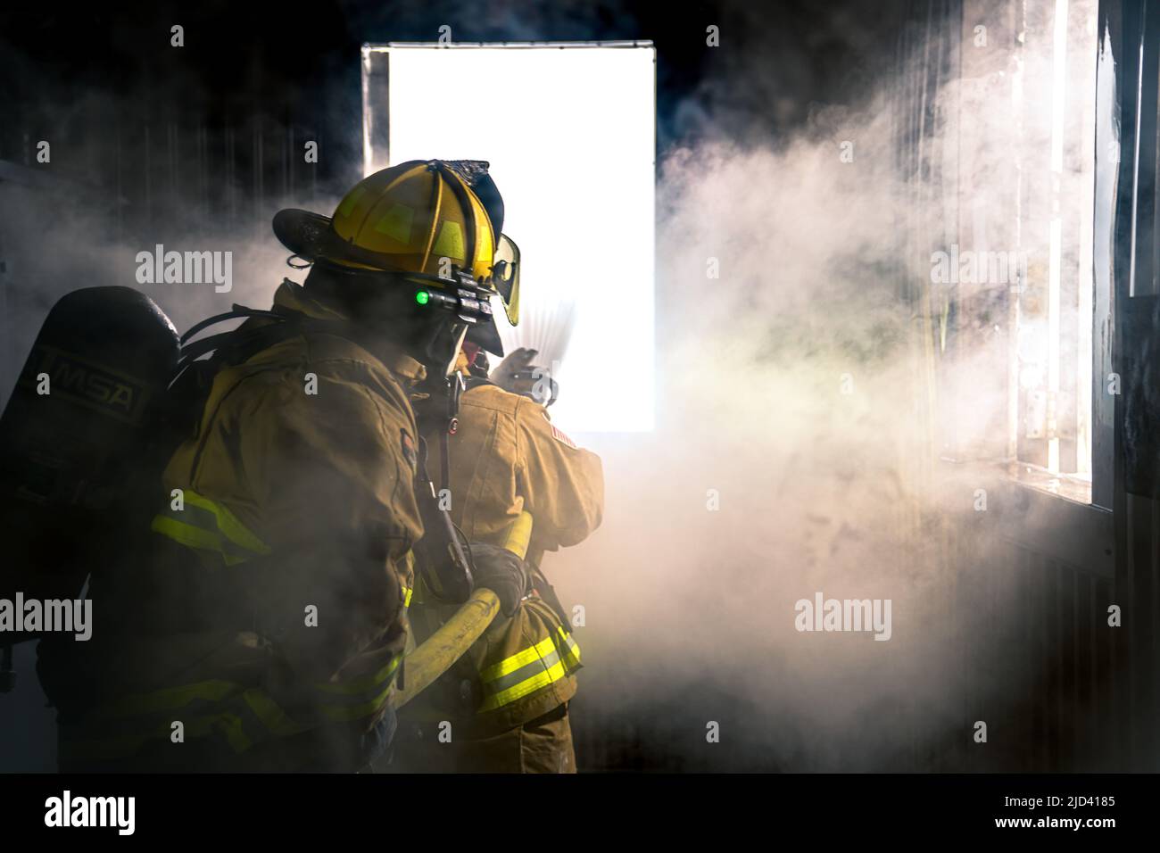 Mitglieder der 110. Wing Civil Engineering Squadron, Battle Creek Air National Guard Base, Michigan, trainieren zusammen mit lokalen japanischen Feuerwehrleuten während des Einsatzkampfes der CE Squadron (DFT) mit einem simulierten Gebäudebrand auf der Yakota Air Base, Japan, 14. Juni 2022. Das DFT-Programm bietet wertvolle Schulungsmöglichkeiten, die normalerweise nicht in Heimstationen-Szenarien verfügbar sind, und ermöglicht es Airmen, an Geräten zu trainieren, die sie wahrscheinlich während eines Einsatzes betreiben, aber möglicherweise nicht an ihrem Heimatstandort haben. (USA Foto der Air National Guard von Senior Airman Ryan Bishop) Stockfoto