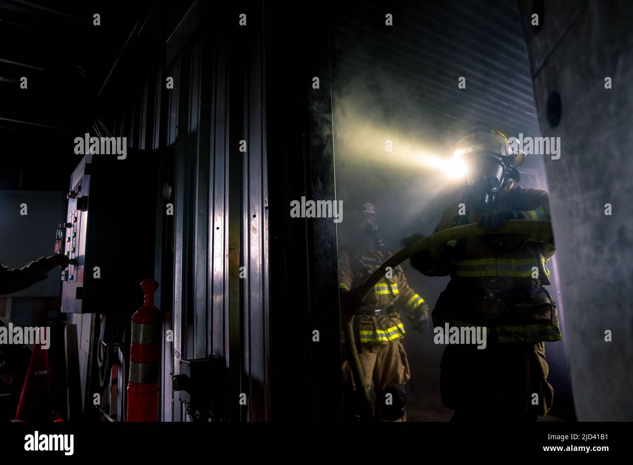 Mitglieder der 110. Wing Civil Engineering Squadron trainieren zusammen mit lokalen japanischen Feuerwehrleuten während des Einsatzverfahrens für Training (DFT) des CE Squadron mit einem simulierten Gebäudebrand auf dem Yakota Air Base, Japan, 14. Juni 2022. Das DFT-Programm bietet wertvolle Schulungsmöglichkeiten, die normalerweise nicht in Heimstationen-Szenarien verfügbar sind, und ermöglicht es Airmen, an Geräten zu trainieren, die sie wahrscheinlich während eines Einsatzes betreiben, aber möglicherweise nicht an ihrem Heimatstandort haben. (USA Foto der Air National Guard von Senior Airman Ryan Bishop) Stockfoto