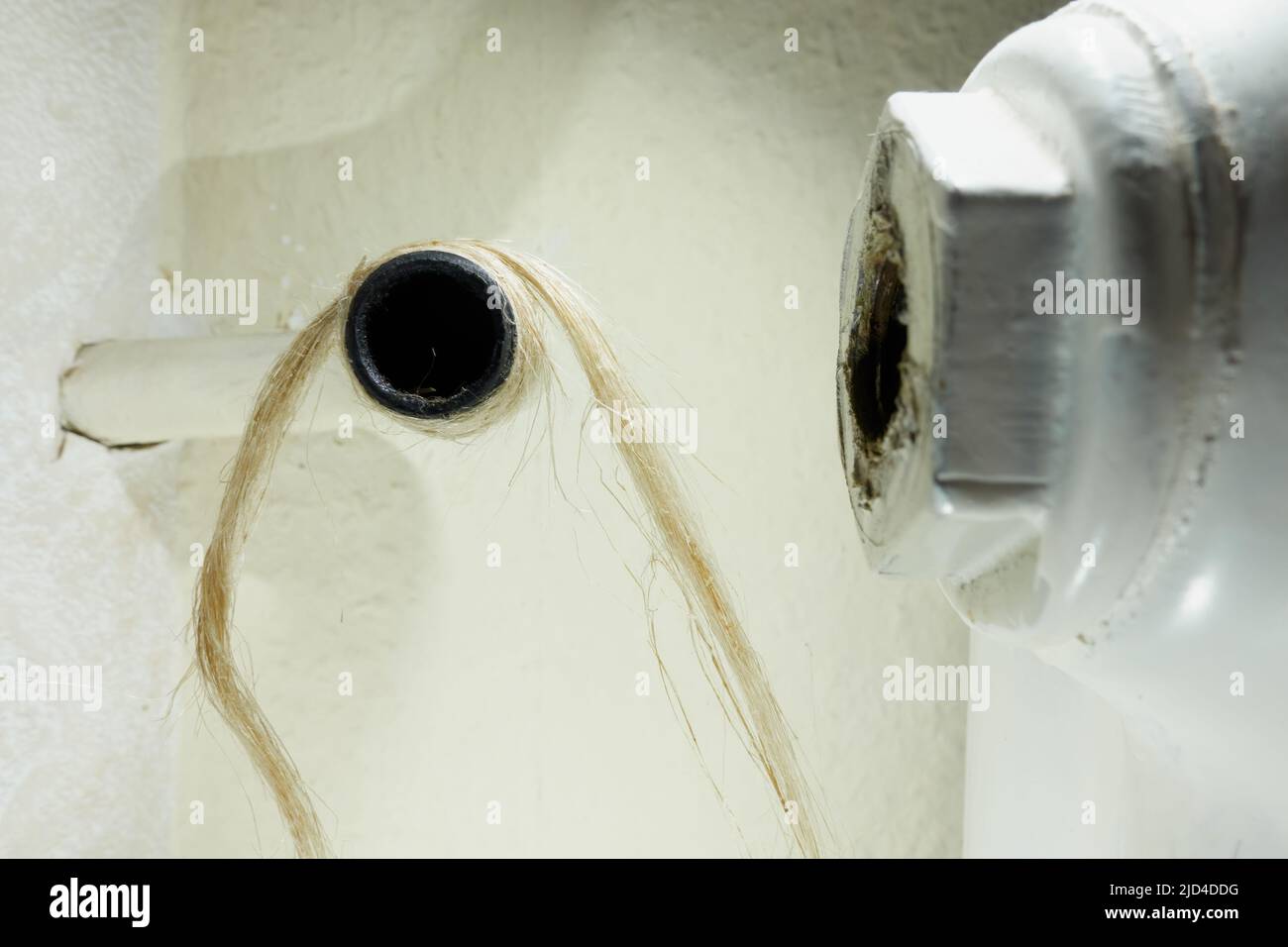 Heizrohr mit Hanf abdichten. Thermostatventil an der Heizkörperheizung austauschen. Schraubverbindung in der Installation. Stockfoto Heizrohr mit Hanf abdichten. Thermostatventil an der Heizkörperheizung austauschen. Schraubverbindung in der Installation. Stockfoto