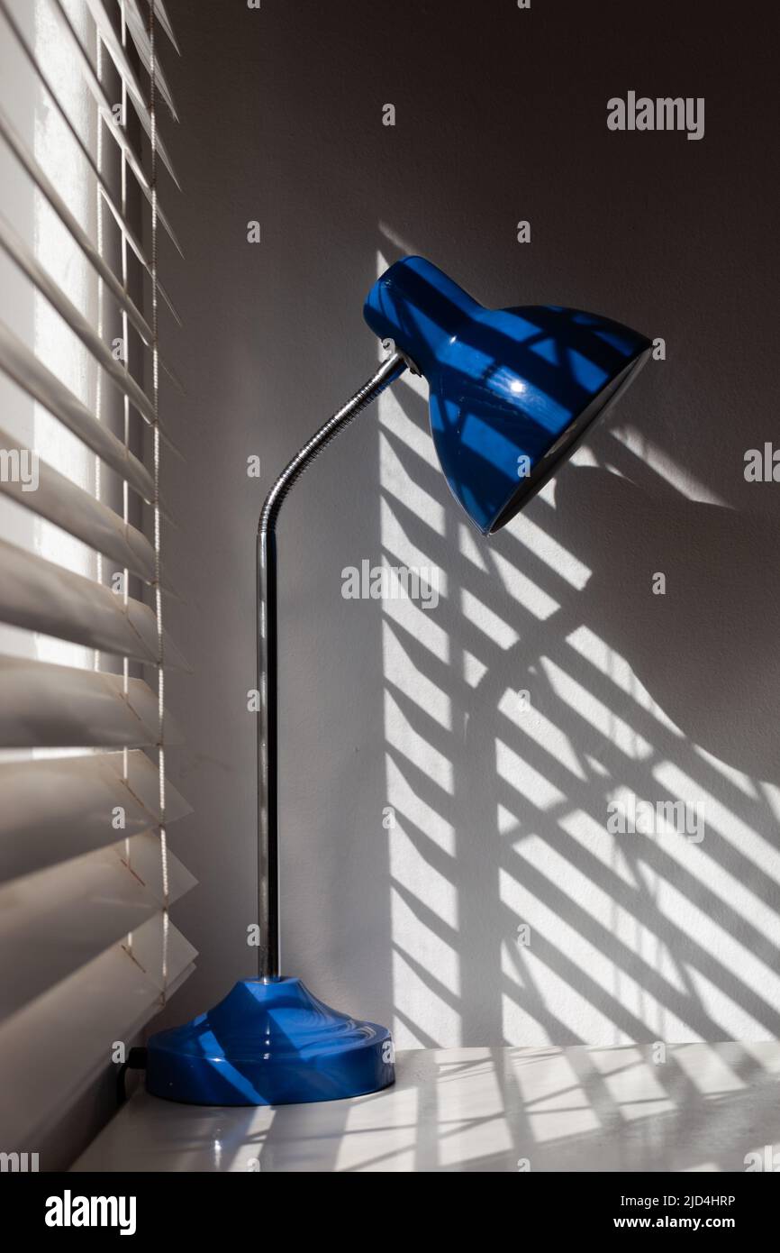 Blaue Lampe neben den Jalousien im Schlafzimmer. L Stockfoto