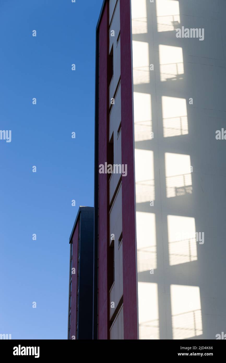 Apartmentblock mit Schatten an der Seitenwand des Nachbargebäudes. Stockfoto