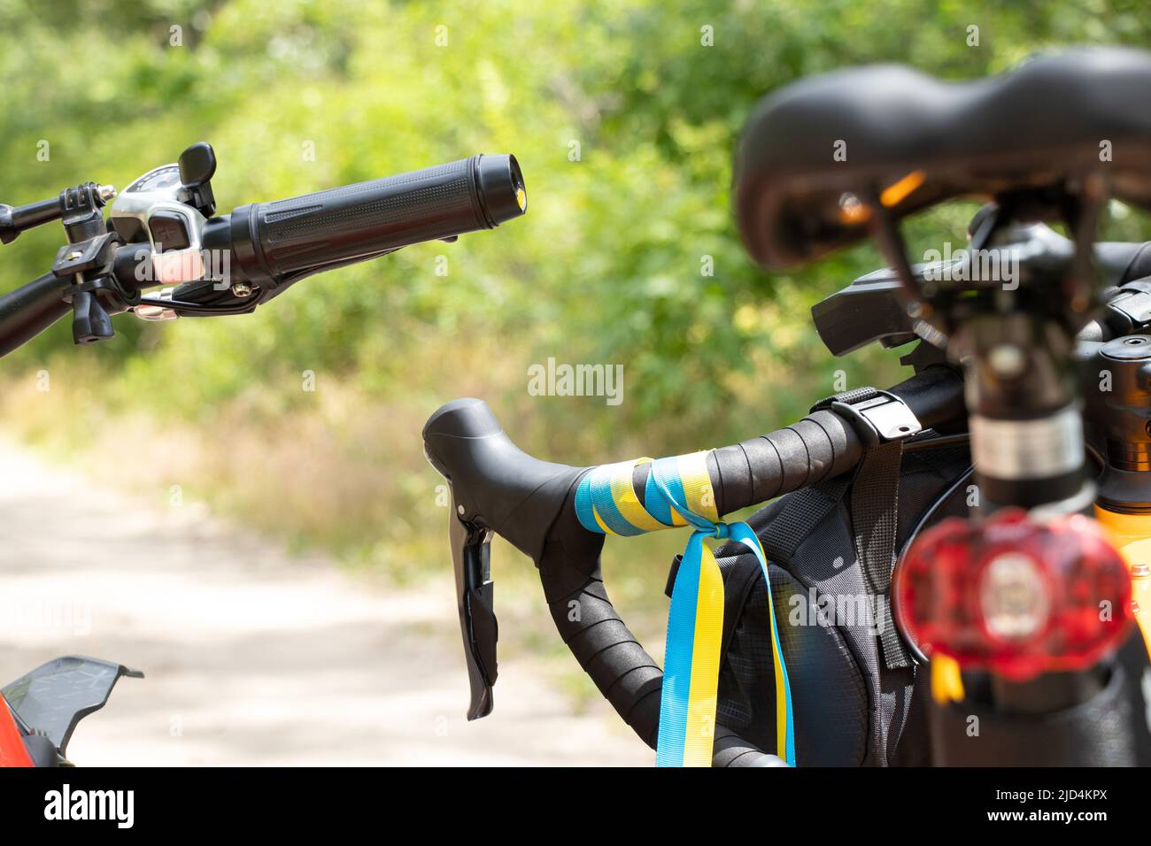 Flagge der Ukraine am Lenkrad eines Sportfahrrads auf der Straße in der Ukraine gebunden, Patriot, Stadtverkehr, Radfahren in der Ukraine 2022 Stockfoto