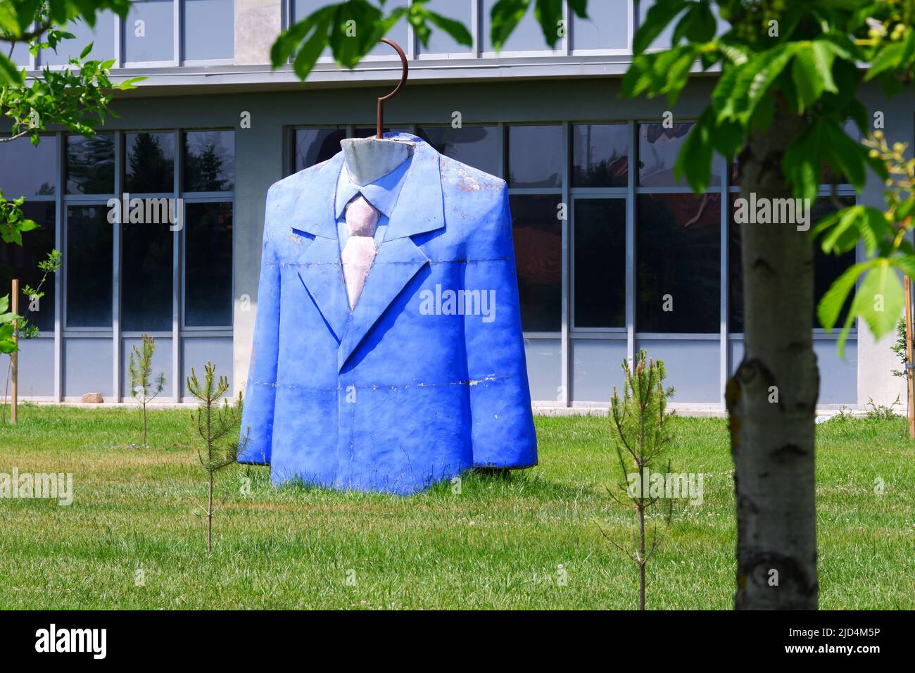 Statue des Anzugoberteil mit blauer Jacke, Hemd und Krawatte im Garten der Designfakultät an einem sonnigen Tag Stockfoto