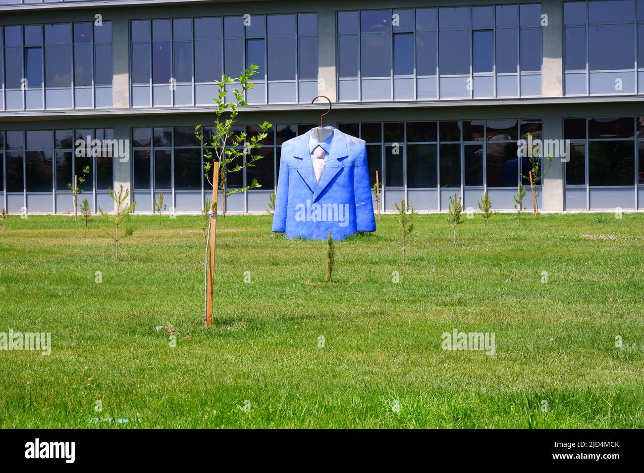 Statue des Anzugoberteil mit blauer Jacke, Hemd und Krawatte im Garten der Designfakultät an einem sonnigen Tag Stockfoto